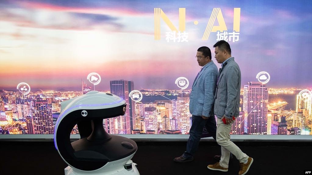 在北京中国国际展览中心举办的第十四届中国国际公共安全与安防博览会上，参观者从一台名为APV3的AI（人工智能）安防机器人身边走过，该机器人配备了人脸识别系统。