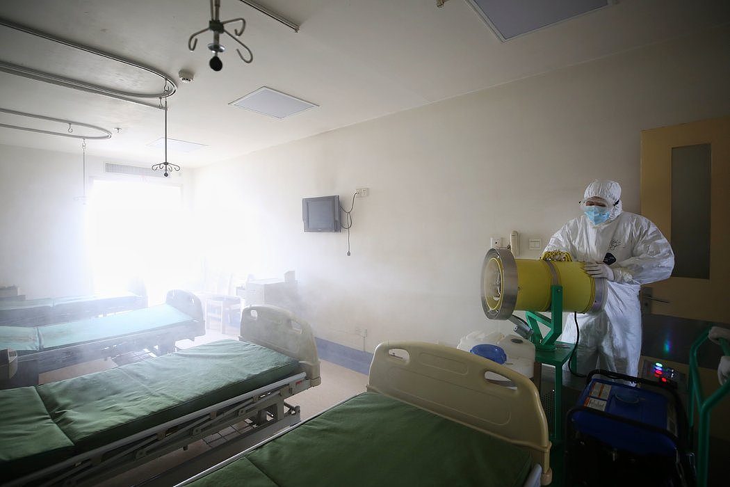 3月，在武汉市红十字会医院，一名医护人员在一个曾安置新冠病毒患者的房间喷洒消毒剂。