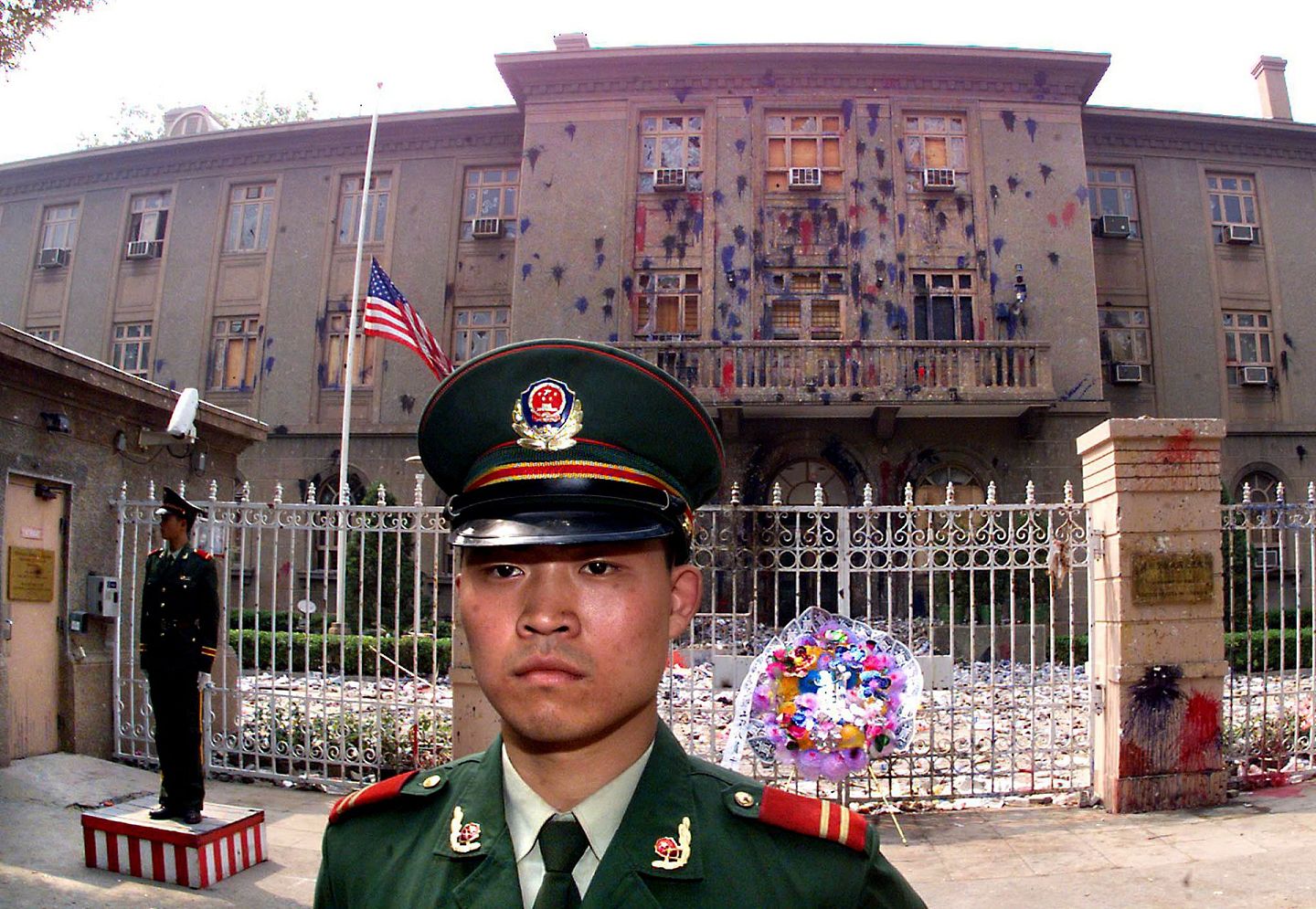 1999年5月12日，遭北京青年学生抗议活动破坏的美国驻华大使馆下半旗，悼念在北约轰炸中国驻南斯拉夫大使馆事件中遇难的三名中国记者。（法新社）
