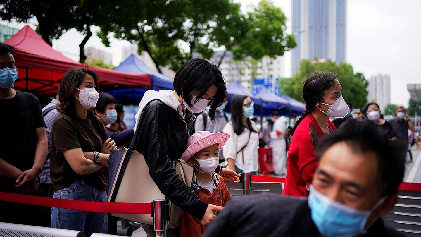 图为2020年5月16日，武汉市戴着口罩的居民排队等候核酸测试。（路透社）