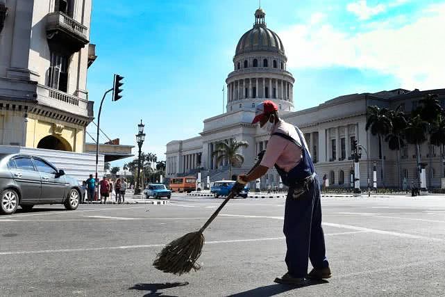 在古巴首都哈瓦那，一名环卫工人戴着口罩工作