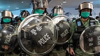 Riot police wearing protective masks stand guard during a demonstration in a shopping mall on 10 May in Hong Kong.