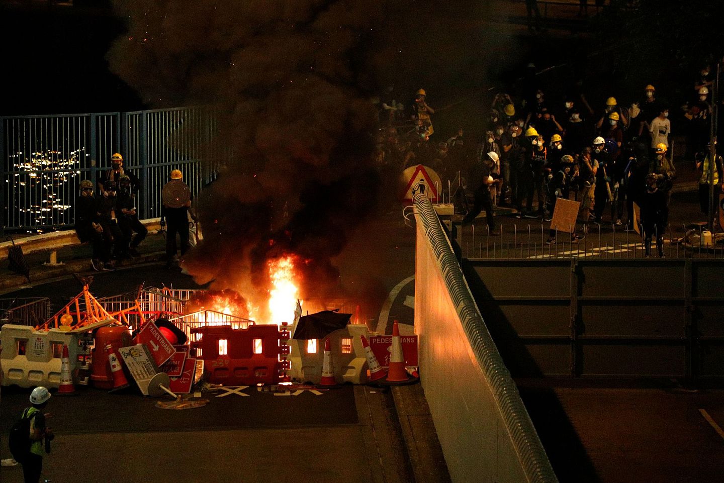 2019年7月21日，香港抗议者点燃路障，阻止防暴警察前进。（AP）