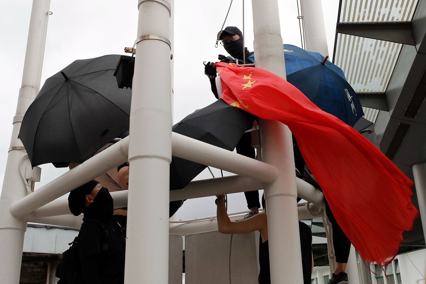 2019年8月3日，抗议者从旗杆上降下中国国旗。（AP）