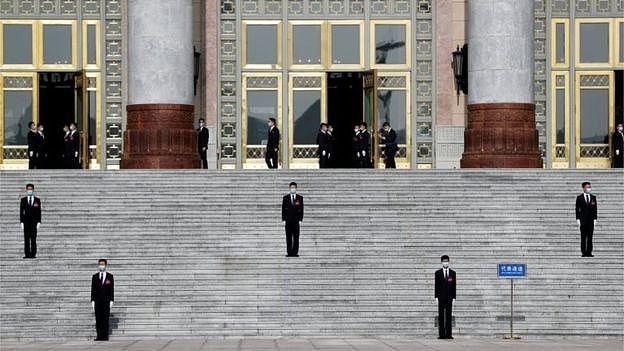 Security personnel wearing face masks following the coronavirus disease (COVID-19) outbreak stand guard outside the Great Hall of the People before the opening session of the National People