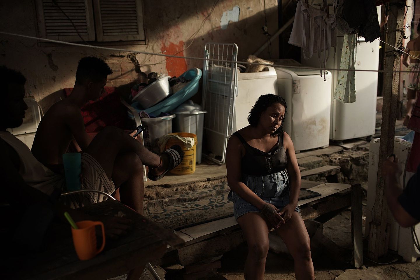 4月15日，在里约的图拉诺贫民窟，美甲师兼七个孩子的母亲莱蒂西亚·马查多（Leticia Machado）无精打采地坐在家中的长凳上。由于疫情，马查多失去了工作。（AP）