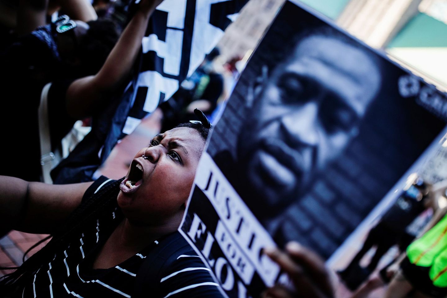 美国警察暴力执法引发民众抗议。图为一黑人女子手持被害人的肖像示威。（路透社）