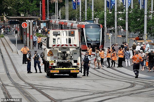 22229660-7793467-Police_and_light_rail_workers_scramble_to_fix_a_tram_pictured_af-a-28_1576375978359 (1).jpg,0