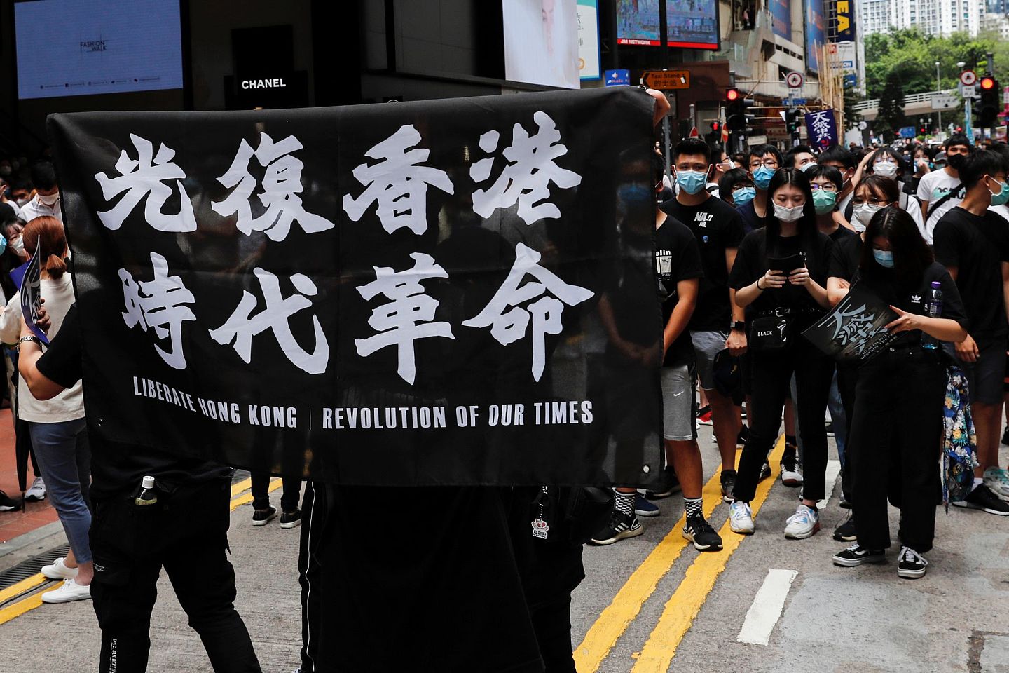 北京推行“港版国安法”引起争议。图为5月24日，香港有示威者发起游行抗议北京推行“港版国安法”，期间高举“光复香港，时代革命”的旗帜。（路透社）
