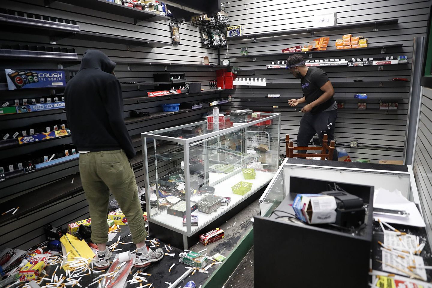 5月29日，明尼阿波利斯的民众进入一家被抢劫的便利店。（AP）