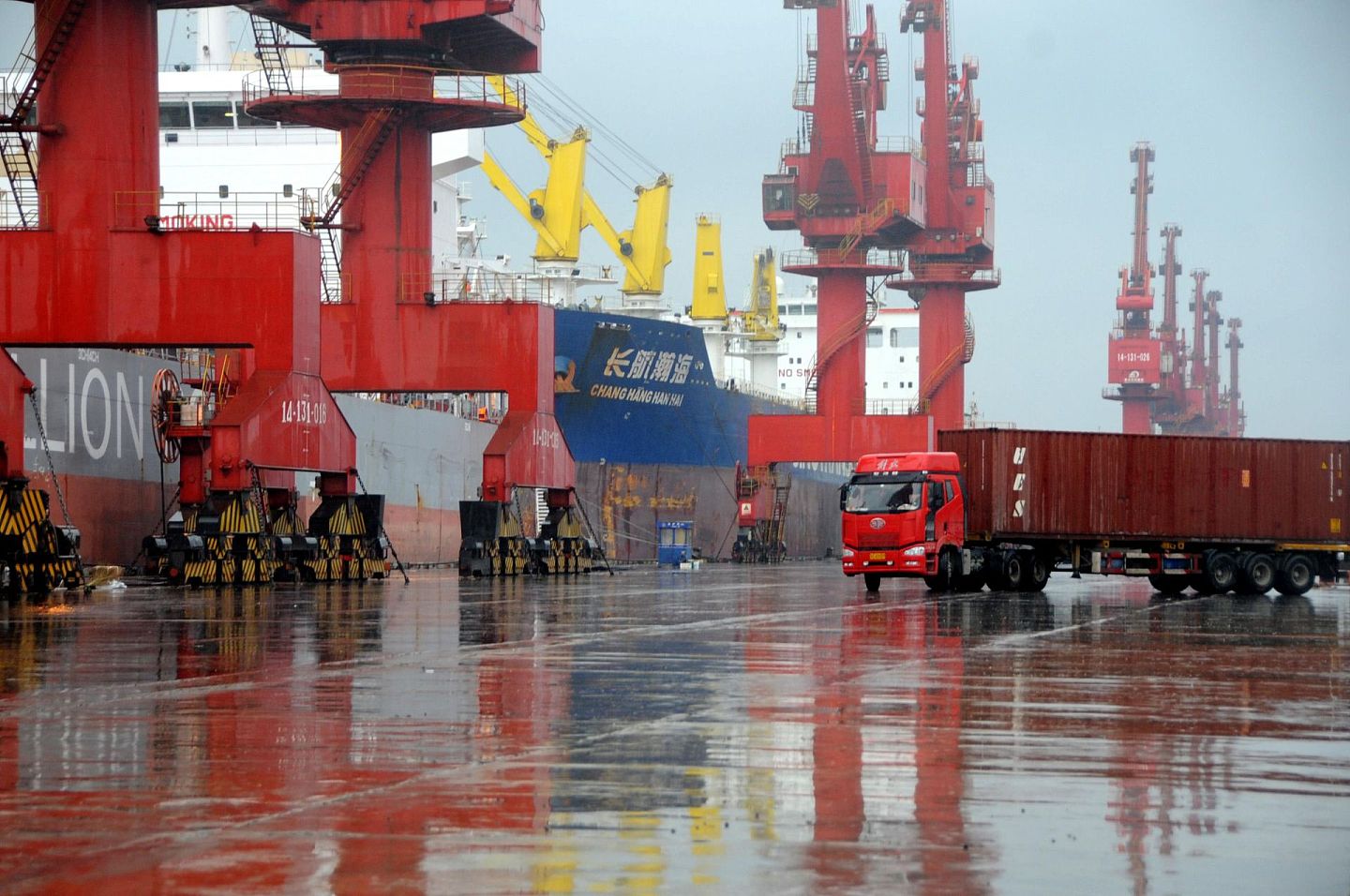 数艘大型远洋运输轮在江苏连云港港散货码头装卸货物，中国制造业正在经历疫情冲击后缓慢复苏。 （新华社）