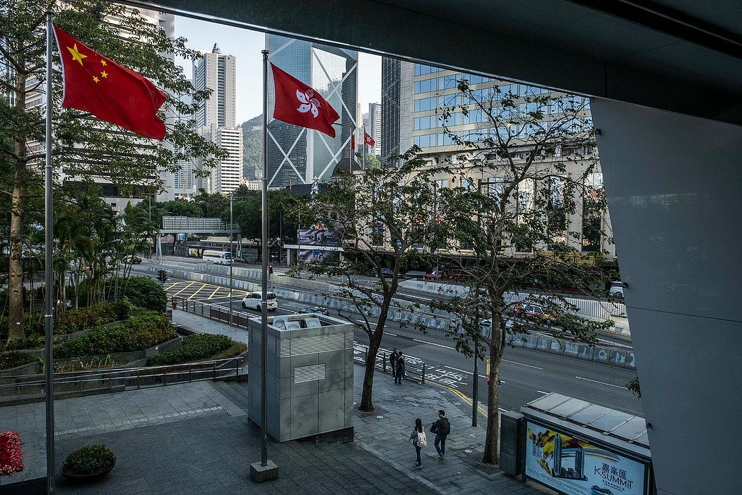 在香港商业区并排飘扬的中国国旗和香港特别行政区区旗。