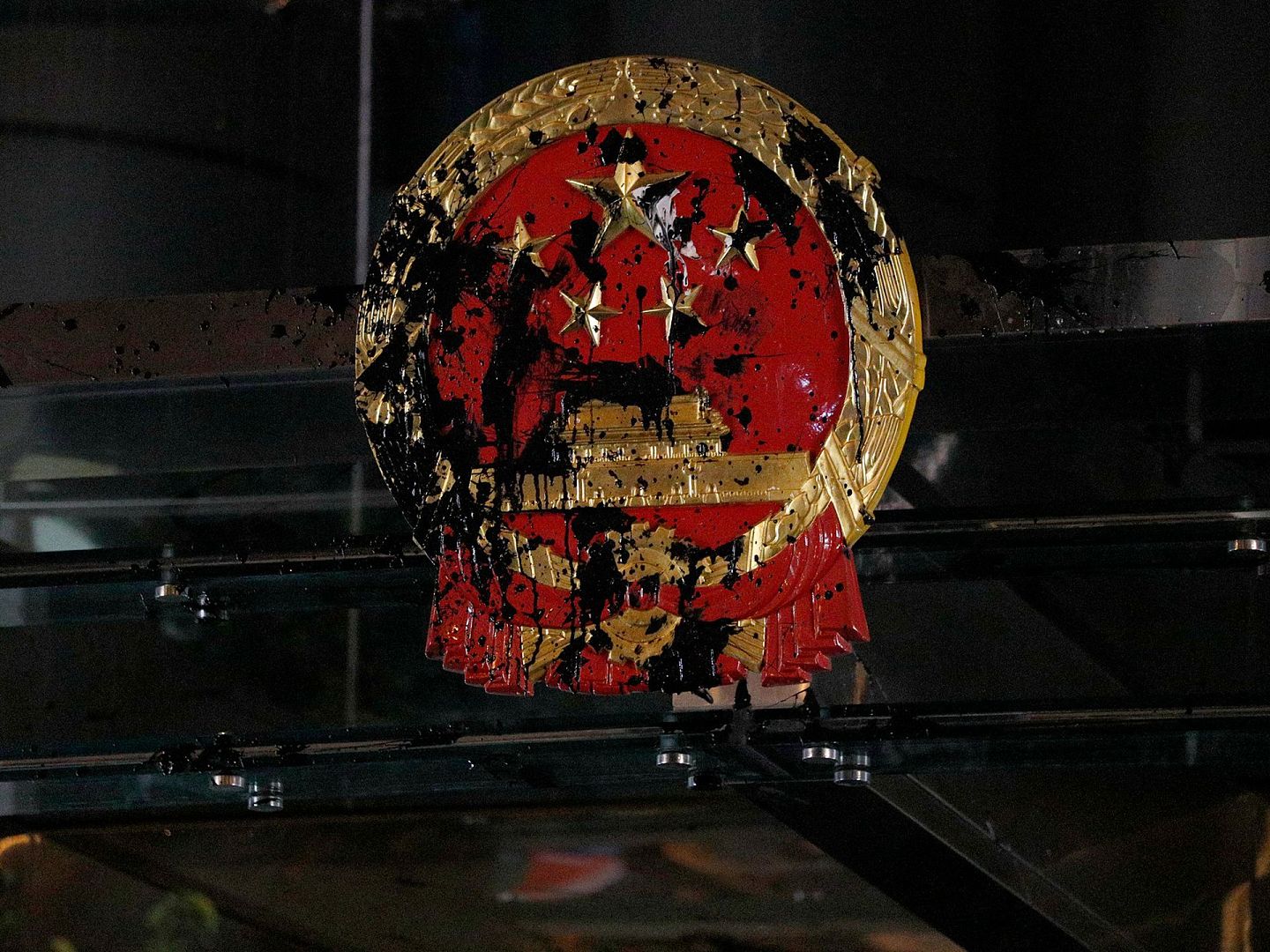 香港中联办大楼外的中国国徽被示威者投掷的黑色油漆玷污。（AP）