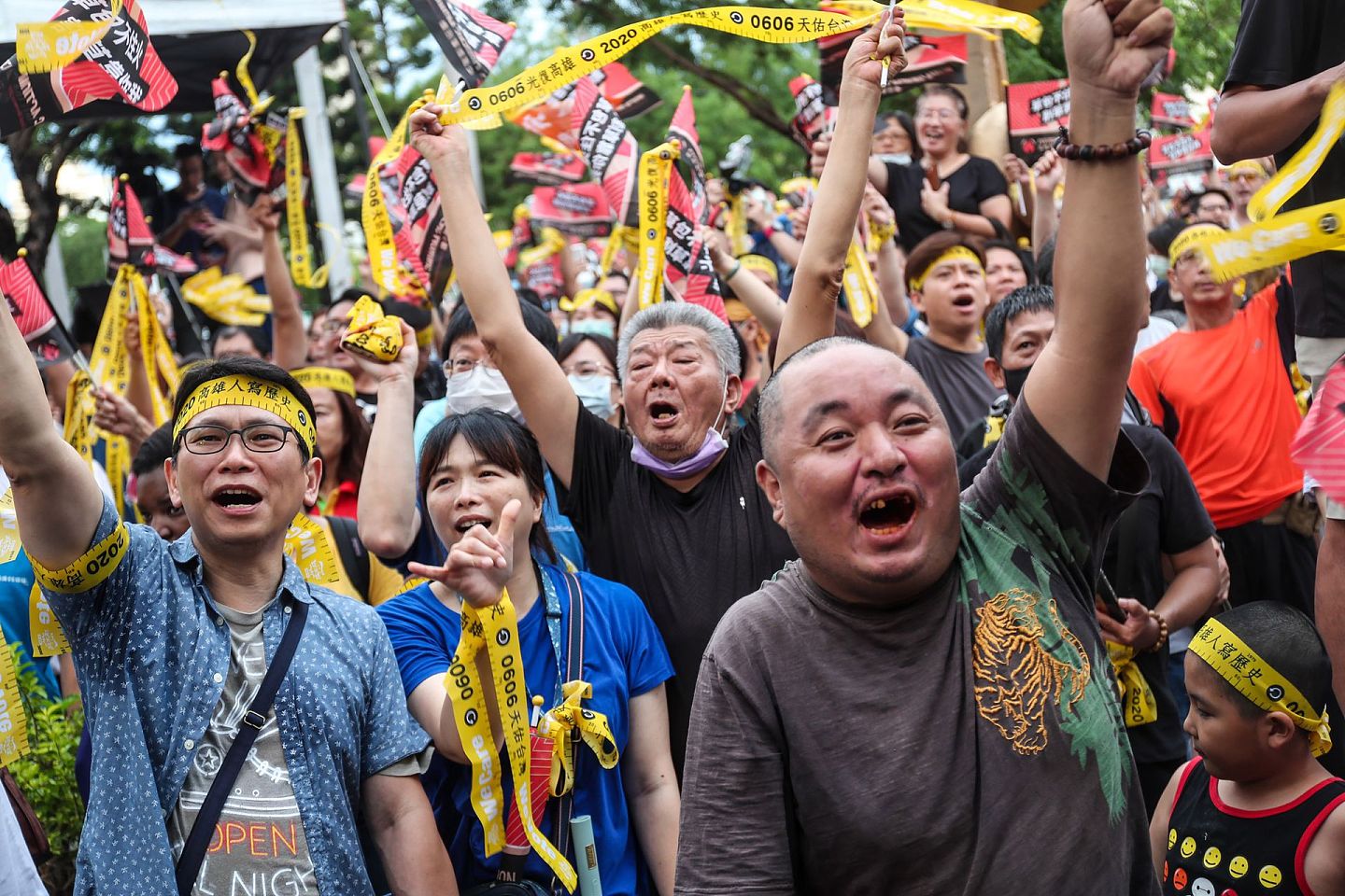高雄市长韩国瑜6日傍晚确定成为台湾首名被罢免的直辖市长，罢韩总部外民众获知结果底定都相当亢奋，开心高举双手挥舞黄丝带及旗帜。（中央社）