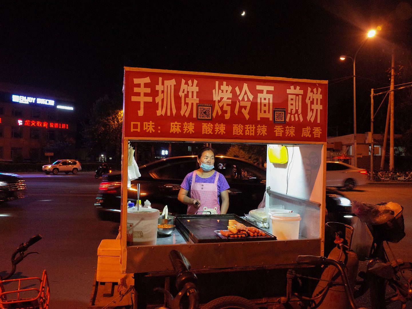 2020年5月28日晚，北京朝阳区街边，临时设摊位卖烤冷面等小吃的流动商贩。（人民视觉）