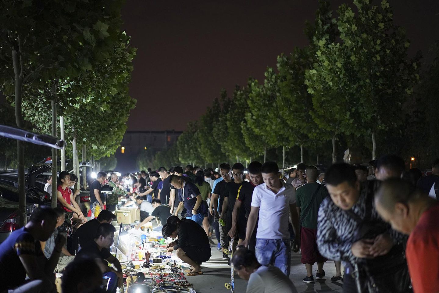 2019年7月的一天夜里，北京朝阳区大柳树鬼市展现着当地的地摊文化，每当此时停车场都被挤得满满当当。（视觉中国）