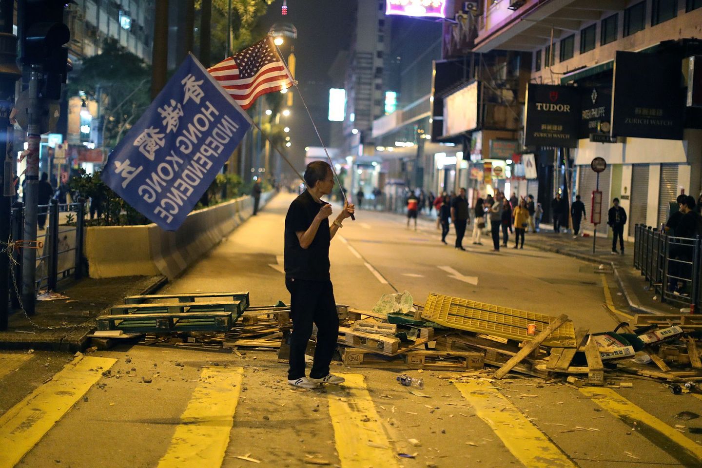2019年12月24日，在香港举行的平安夜游行中，一名香港抗议者站在路障后面。近年香港议题已经成为西方政客施压中国的新着力点。（Reuters）