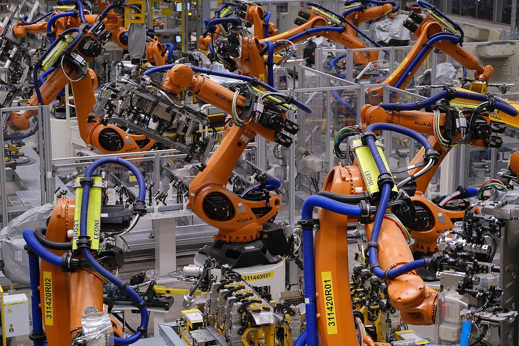在德国茨维考的一家大众汽车工厂，库卡工业机器人正在焊接电动汽车的车身部分。