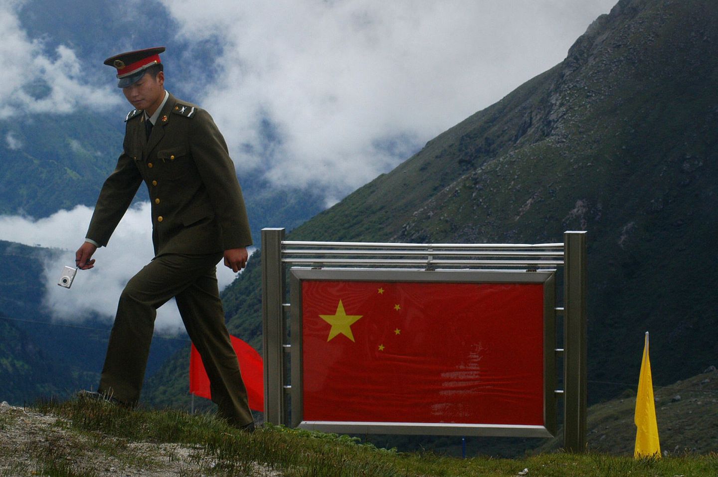 2006年7月5日，连接中国与印度的乃堆拉山口即将重新开放，一名中国士兵从边界围栏旁走。（视觉中国）