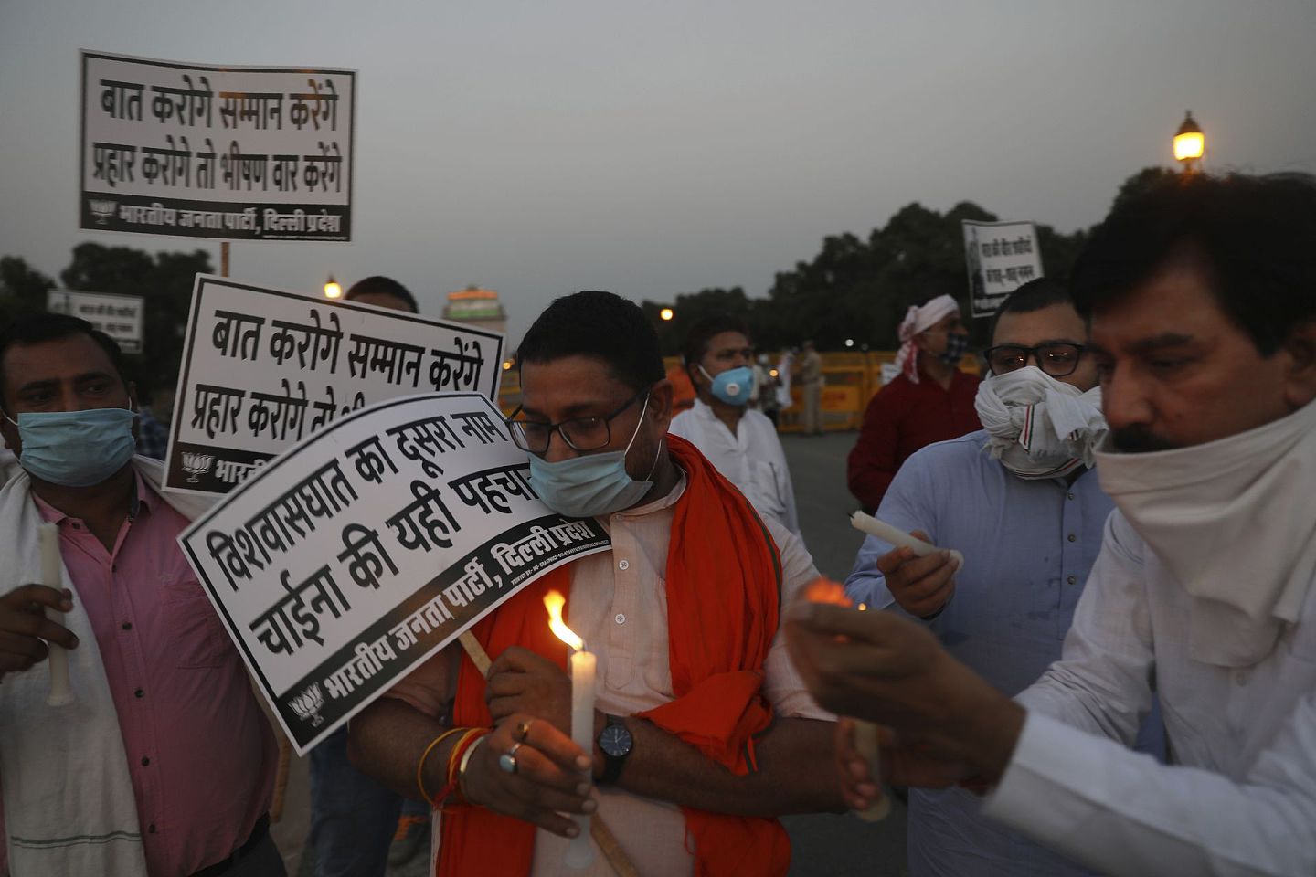 6月17日，印度执政党印度人民党成员在新德里的印度门纪念碑前游行，手持蜡烛，向在拉达克地区与中国士兵对峙中丧生的印度士兵致敬。印着印地语的标语上写着：“如果你说话，我们会尊重；如果你攻击，我们会做出可怕的回应，背叛是中国的第二个名字。”（AP）