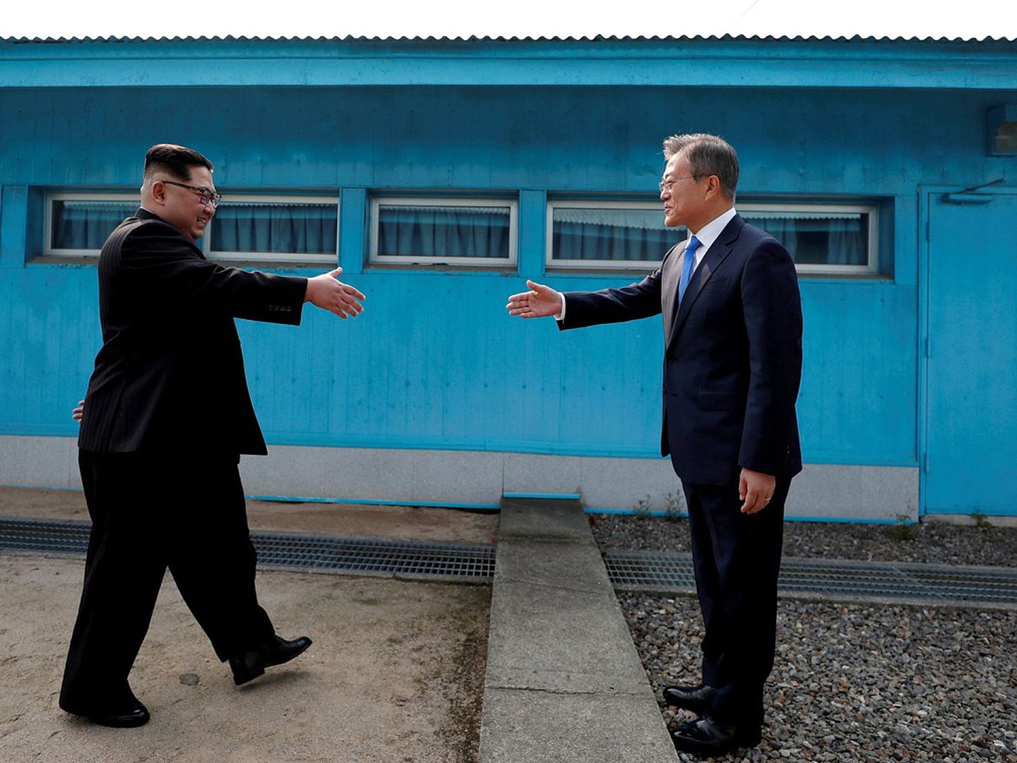 当地时间2018年4月27日，韩国总统文在寅与朝鲜领导人金正恩跨过“三八线”握手。（视觉中国）
