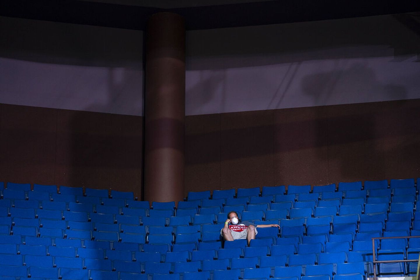 有出席塔尔萨集会的人士在一片空荡荡的蓝色座位上离群独坐。（美联社）