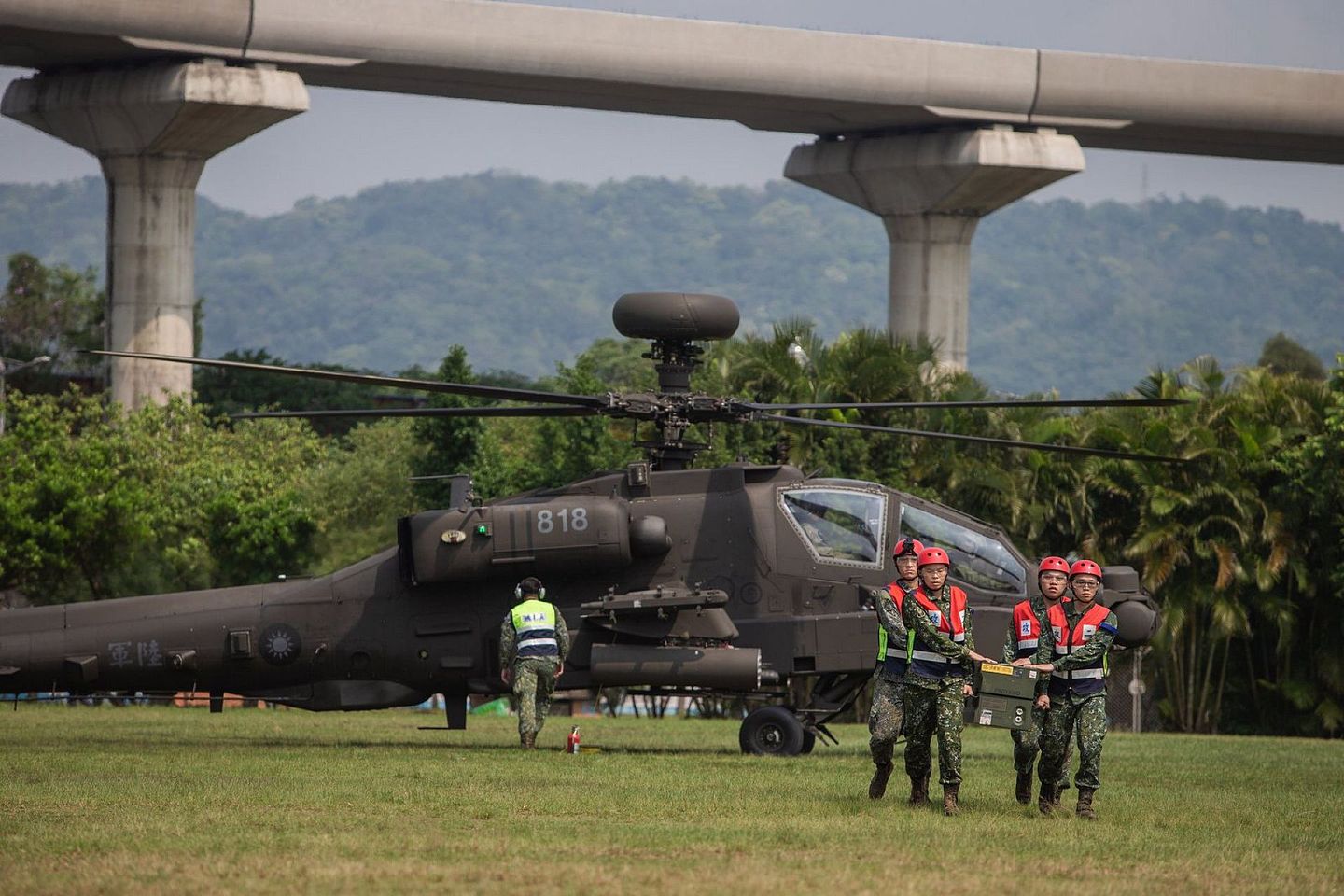 与OH—58D战搜直升机一起模拟应急降落的AH—64E阿帕契战斗直升机，其桅顶上布有长弓雷达，模拟战时的补给弹药应急作业。（台湾国防部）