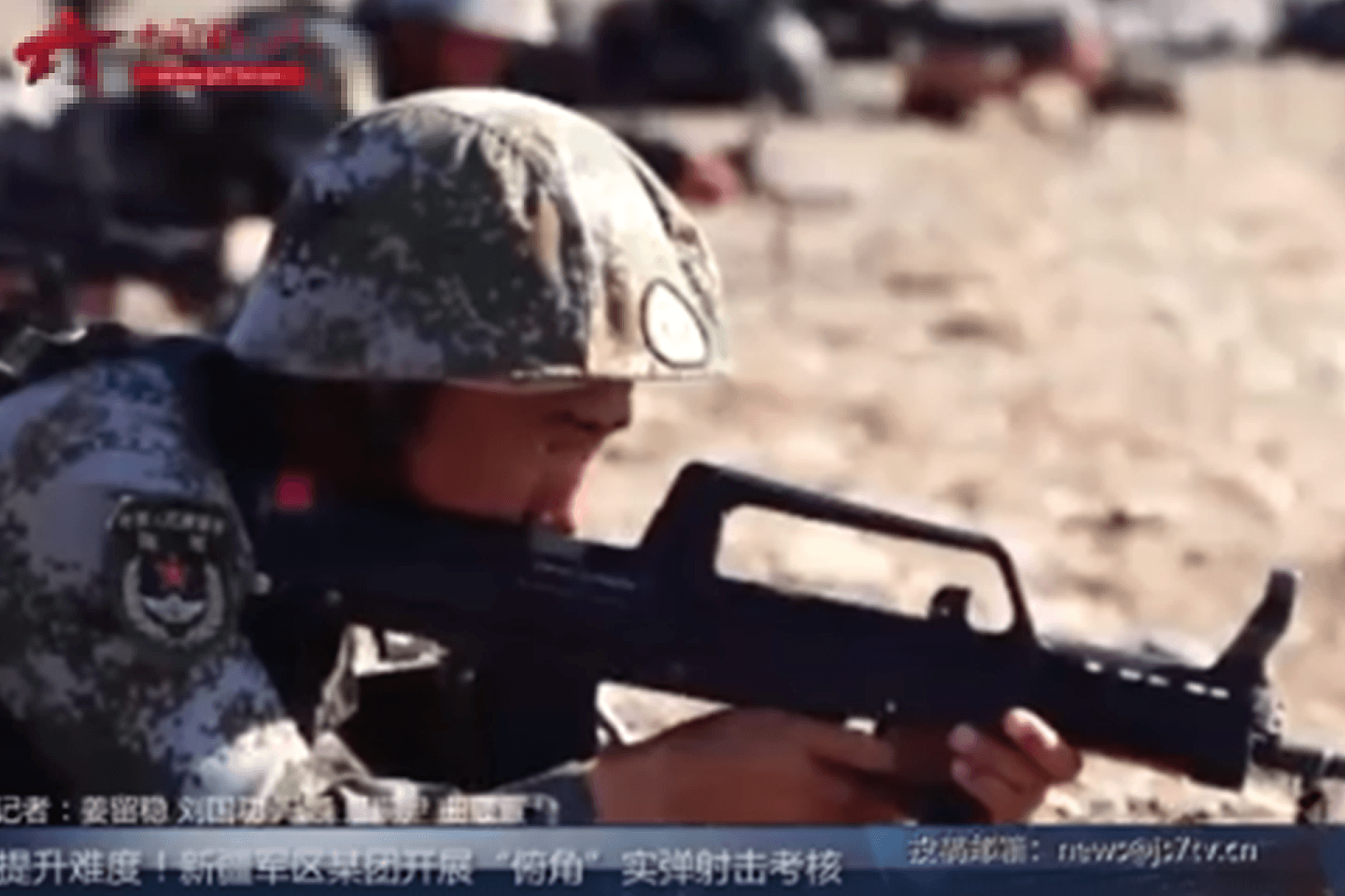 新疆军区开展“俯角”实弹射击考核，士兵举枪准备射击。（中国军视网视频截图）