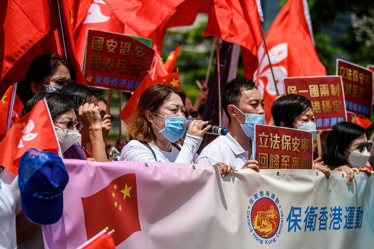 2020年6月30日，在香港政府总部附近举行的集会上，亲中国的支持者展示着中国国旗和香港国旗。（AFP）