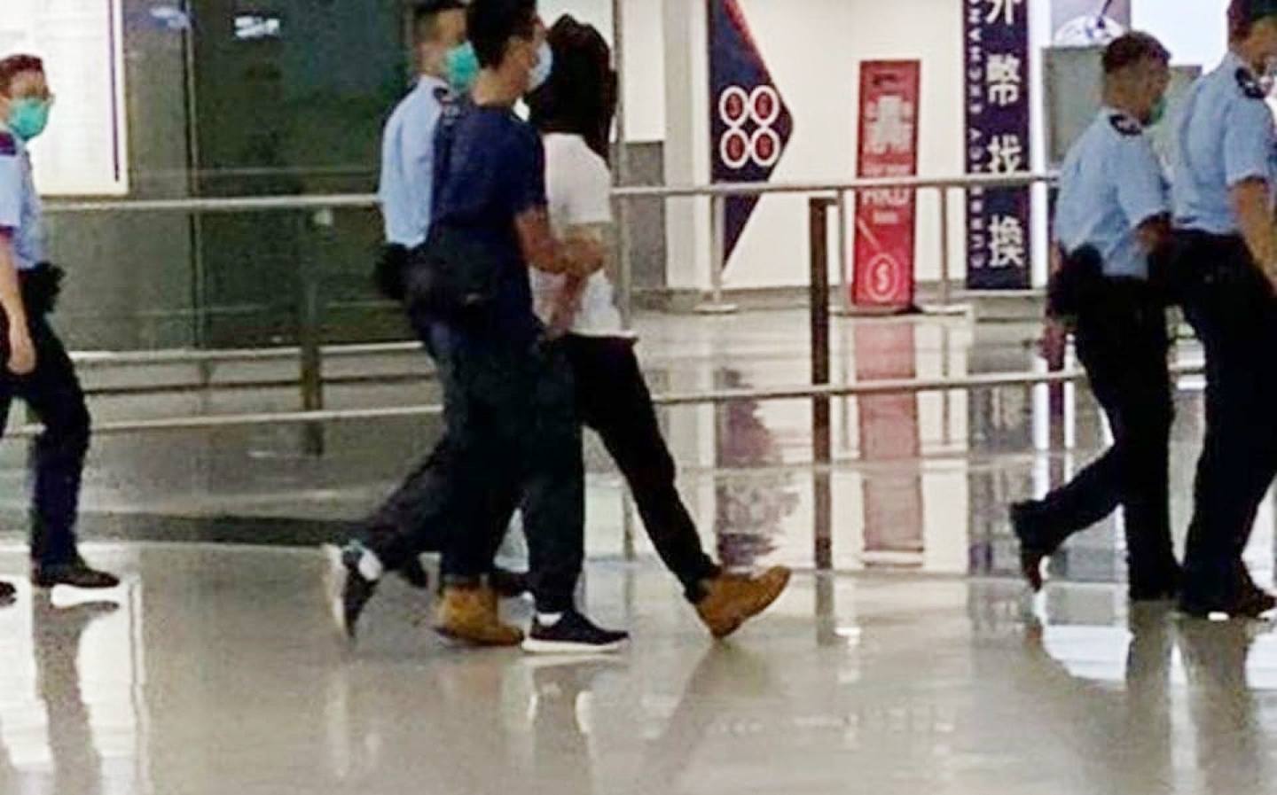 网传被捕人由警员押离机场时的相片。