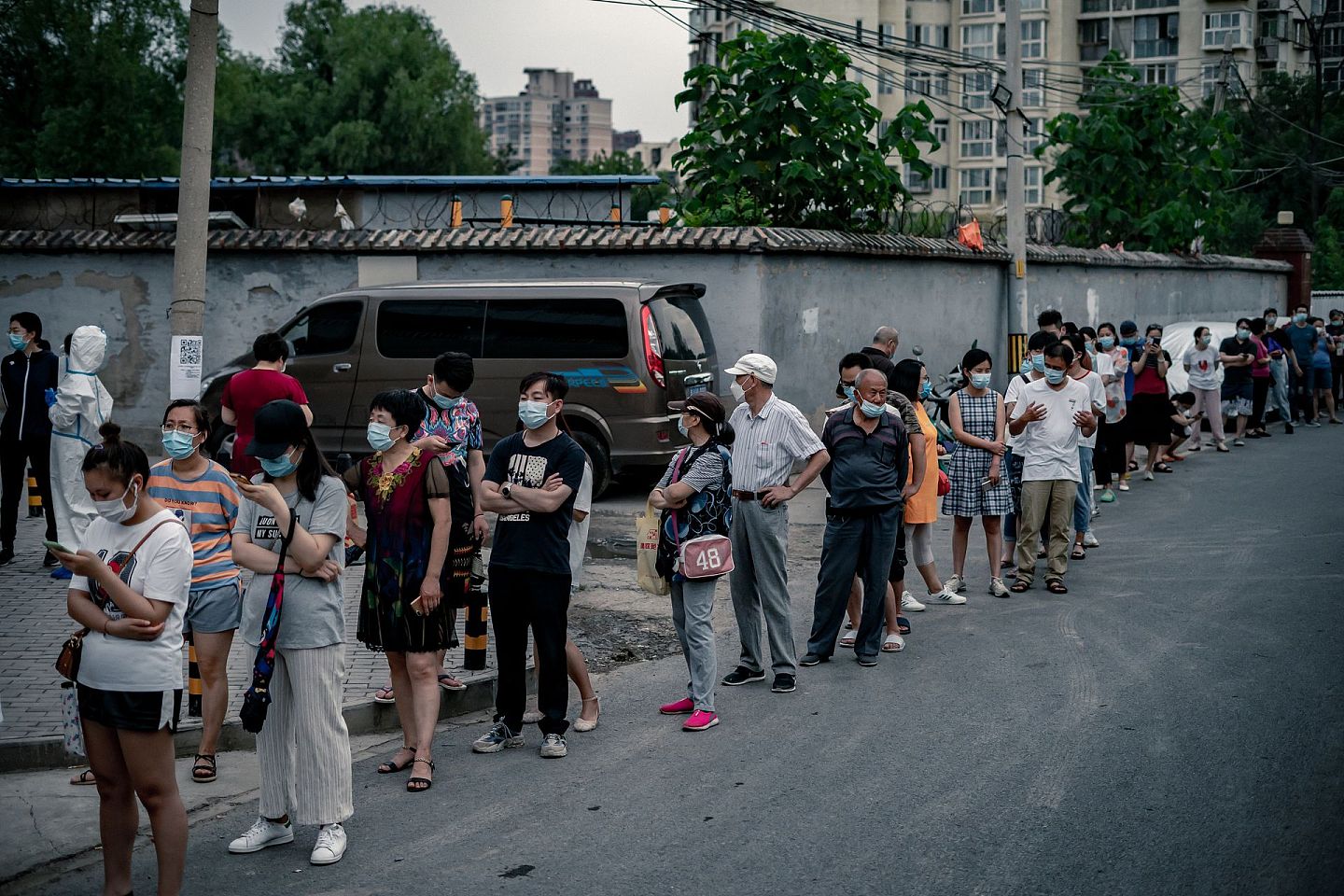 6月25日，北京市丰台区大红门街道的居民排队等待进行社区组织的核酸检测，排除隐患。大红门街道属于中风险街道，在“应检尽检”范围内。（人民视觉）