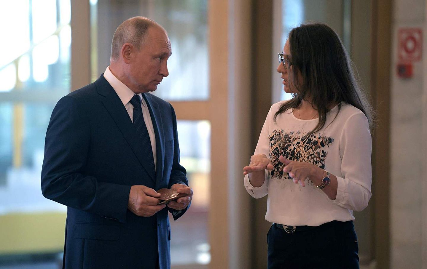 普京在投票站和一名工作人员交流。这次公投十分重要，事关普京的政治未来走向。（Reuters）