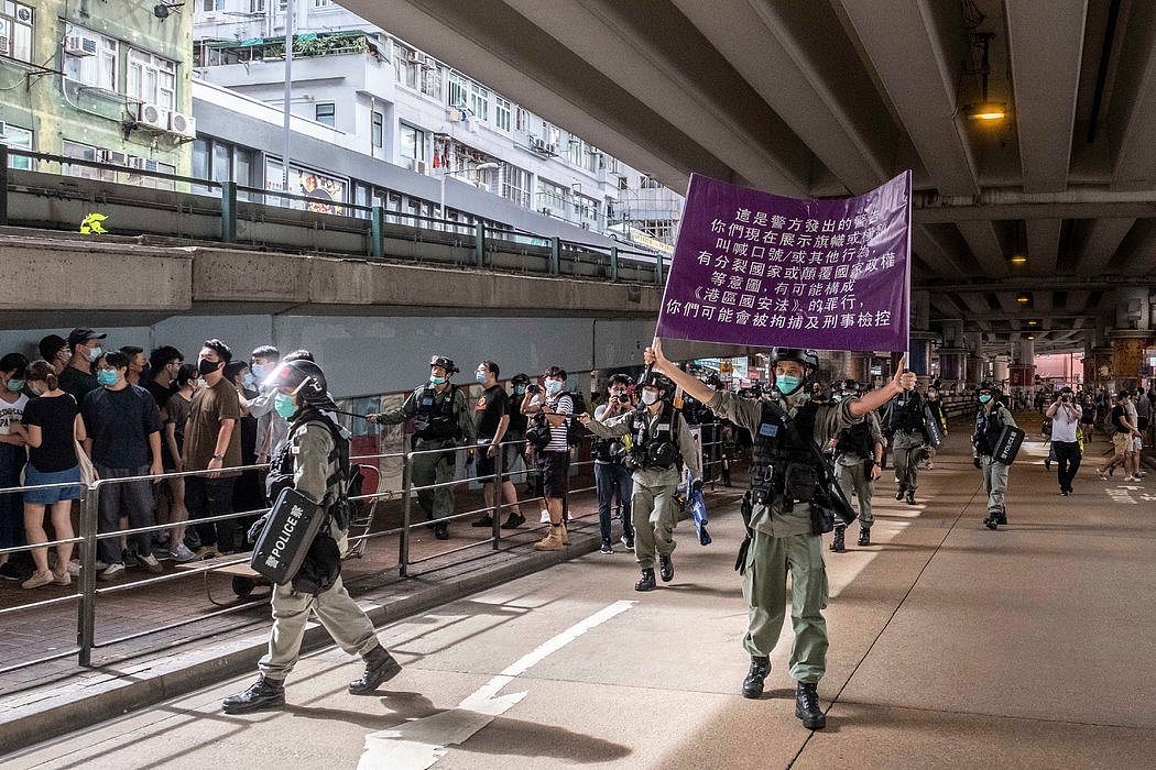 香港警察周三举着紫色旗帜，警告抗议者哪些行为违反《港区国安法》。