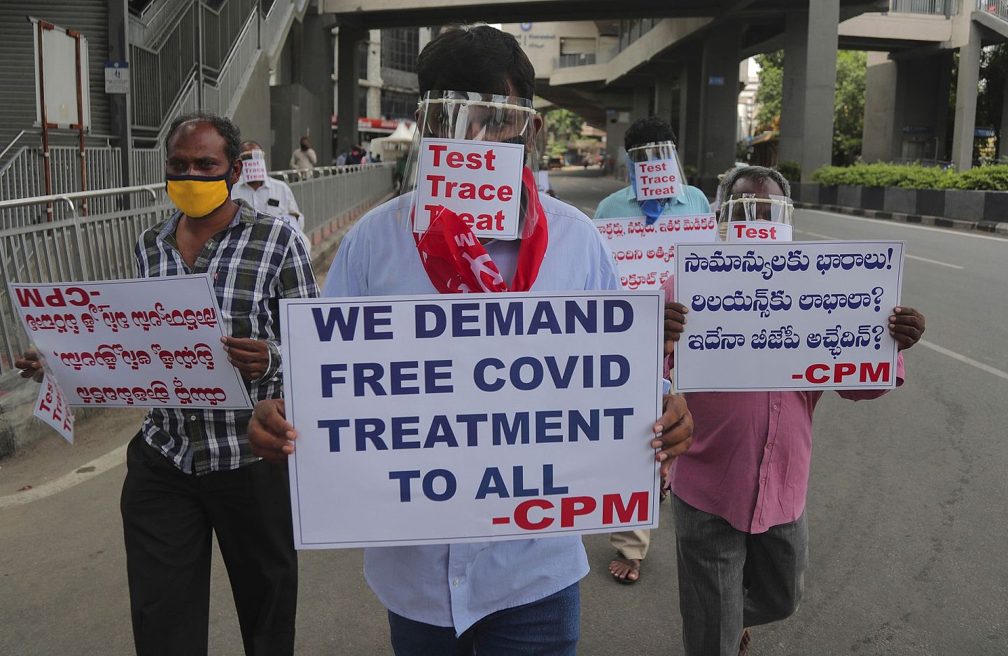 印度国内新冠疫情形势严峻，图为2020年6月29日，印度海得拉巴有人举着标语抗议，要求邦政府增加对所有新冠肺炎患者的检测和免费治疗。（AP）