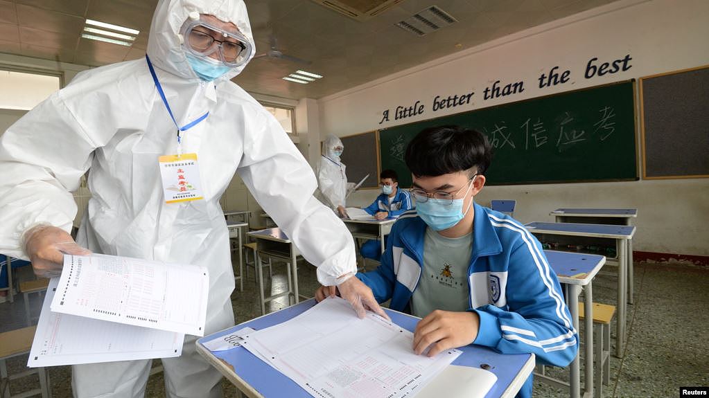 中国河北邯郸一所高中在举行模拟高考时身穿防护服的监考老师在发试卷。（2020年7月1日）