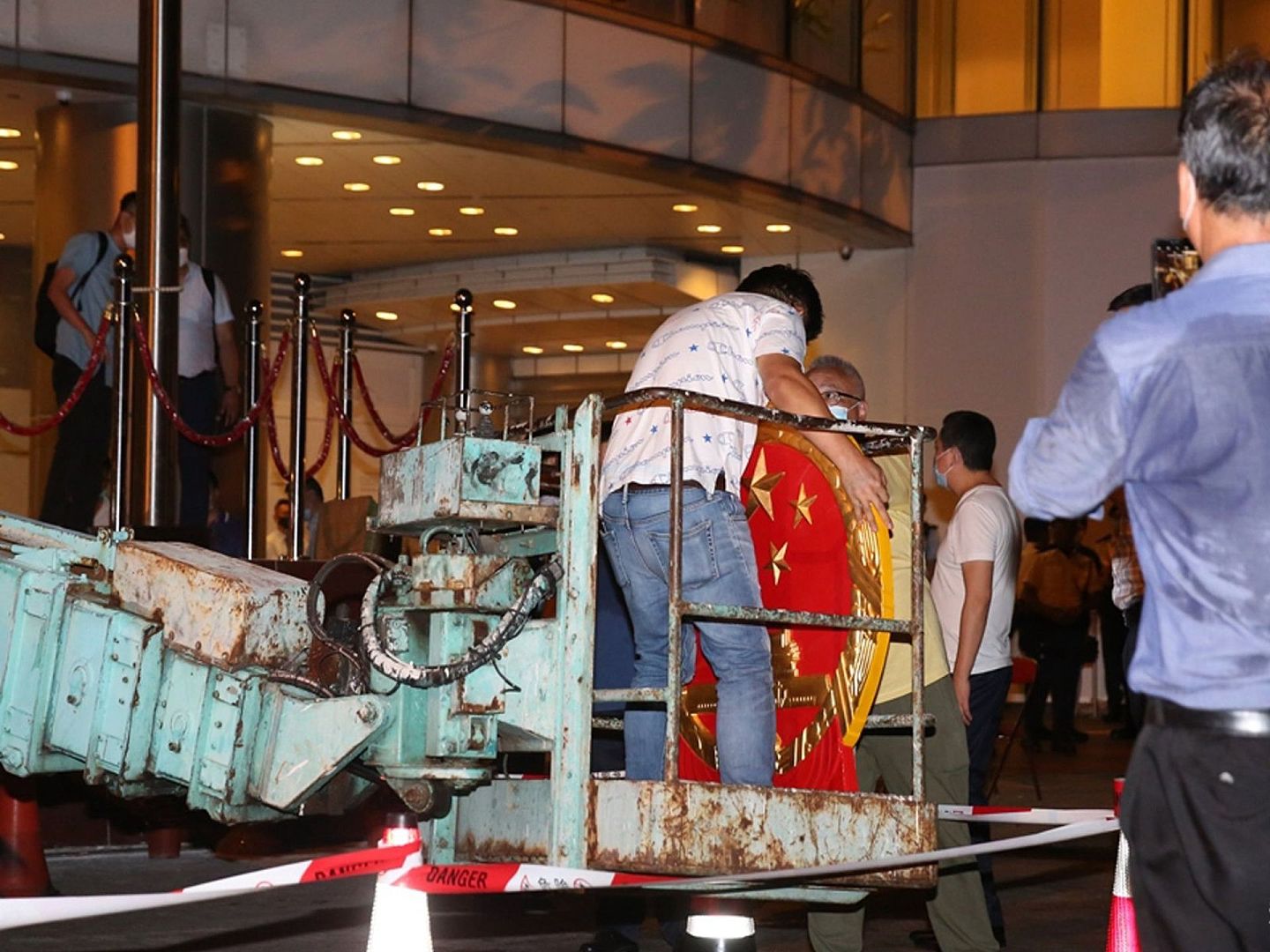 工作人员搬运中国国徽，维景酒店内灯火通明。（HK01）