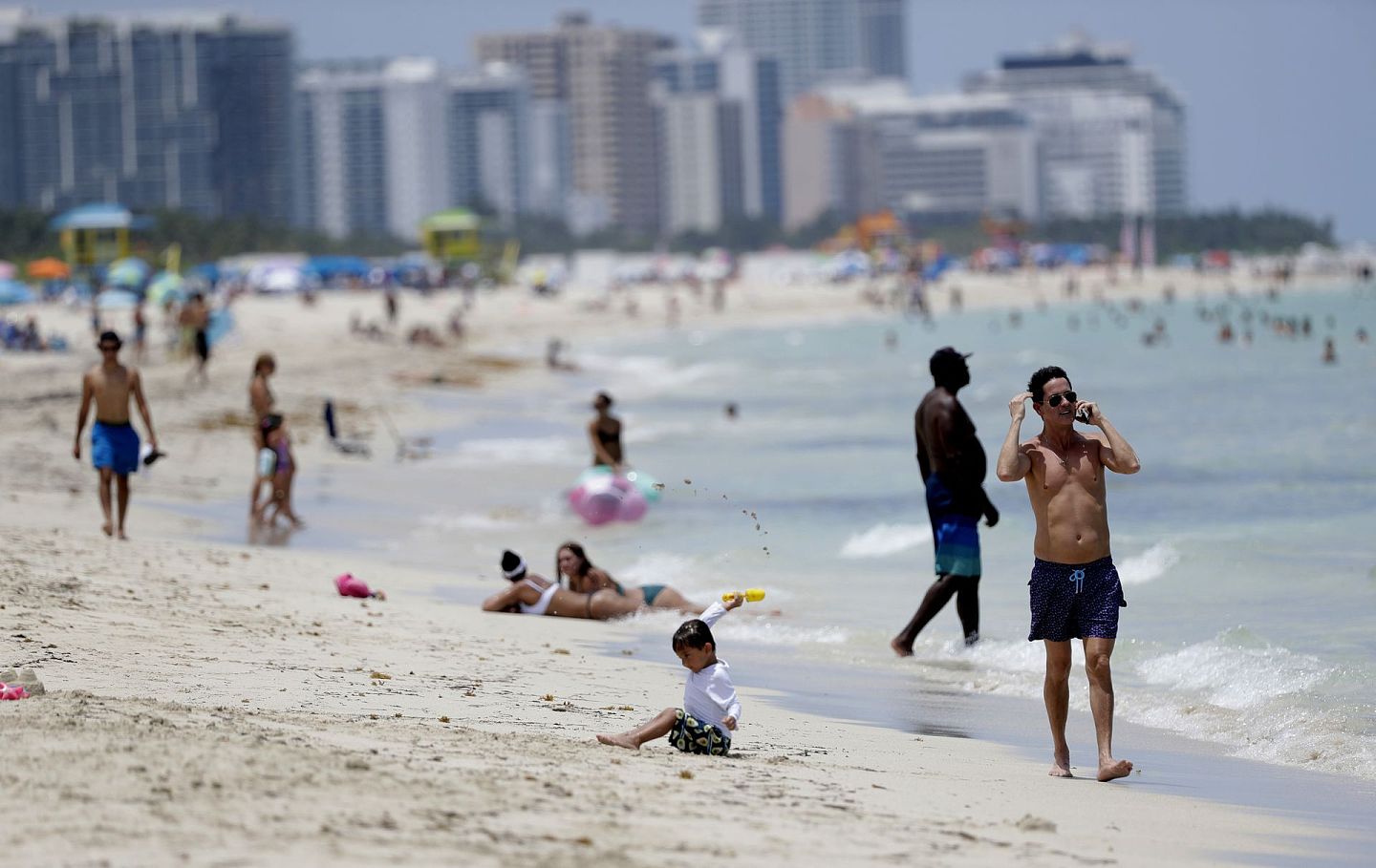 7月7日，不少游人在佛罗里达著名的南海滩迈阿密海滩冲浪。南海滩迈阿密海滩此前于7月3日至6日关闭，以防止新冠病毒的传播。（AP）