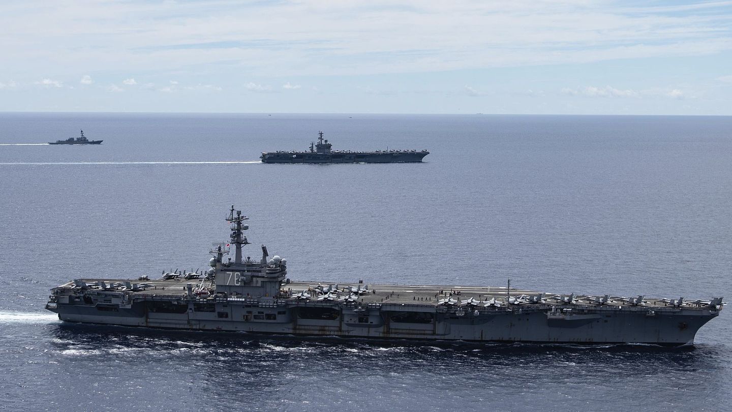 图为美国海军提供的照片，可见在7月6日美国航母里根号（前）及尼米兹号（后）在南海水域航行。（AP）