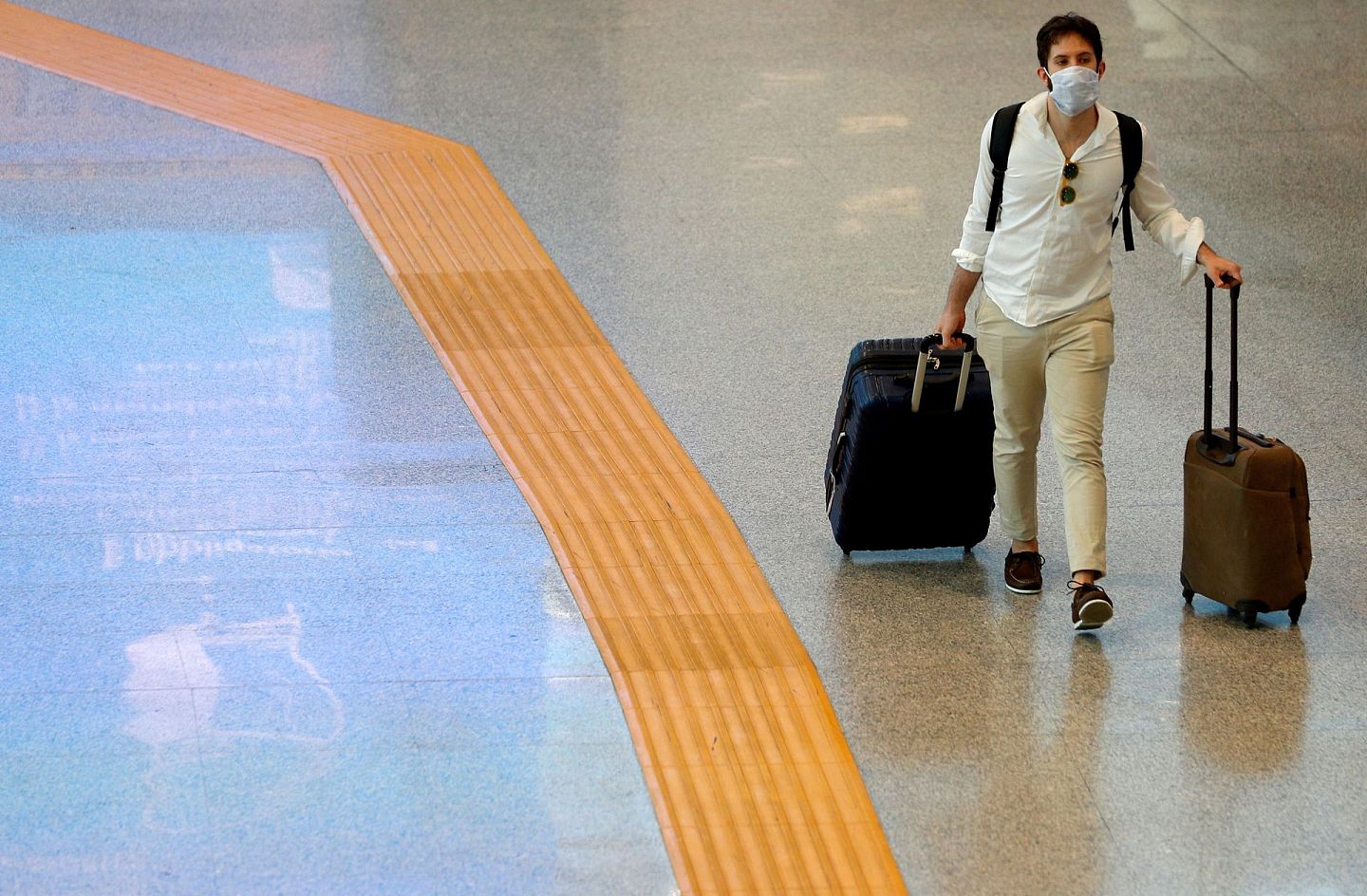 一位戴著口罩的旅客在罗马法林明高机场。6月3日，政府宣布了一系列解除封锁措施为重新迎接游客做准备。（路透社）