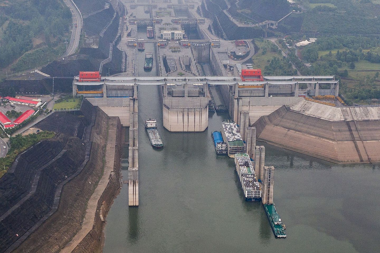 2020年6月8日，湖北宜昌，船舶有序通过三峡五级船闸。水位下降后的消落带清晰可见。（人民视觉）