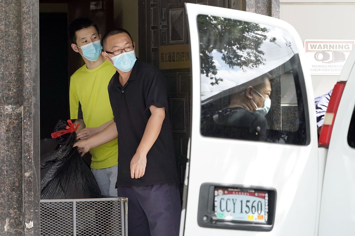 两名中国驻休斯敦总领馆人员打包转运物品。（AP）