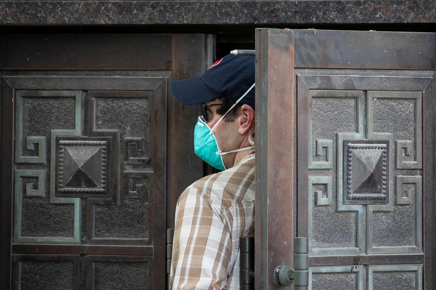 中国雇员离开领事馆后，一名便衣美国安全官员进入领馆后门。（Reuters）