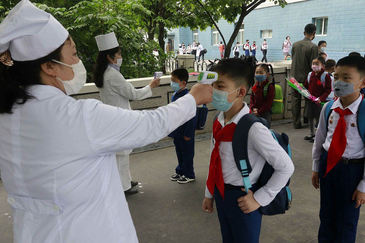 朝鲜小学生进入学校之前要接受体温检测。（AP）