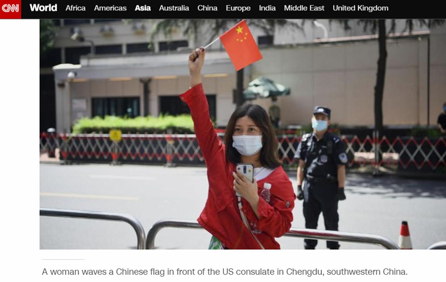 一位中国女孩在美国驻成都领事馆前举起中国国旗，这一幕正好被CNN直播镜头捕捉。（CNN新闻网截图）