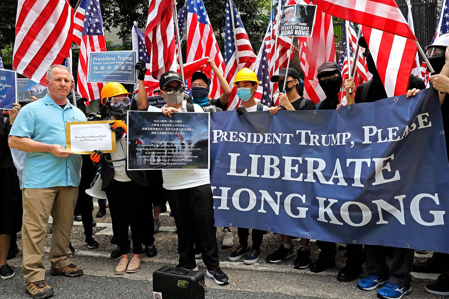在2019年的香港示威风潮中，美国驻香港领事馆代表（左）总能适时出现，并展示抗议者的和平一面。（美联社）