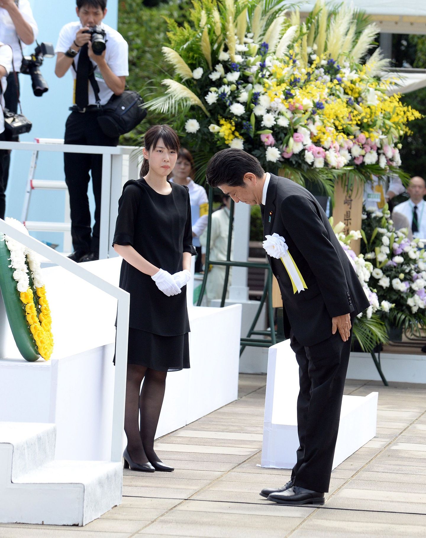 2016年8月9日，在日本长崎和平公园，日本首相安倍晋三（右）在纪念仪式上鞠躬。 当日，日本长崎举行多种活动纪念美军向长崎投下原子弹71周年。（新华社）