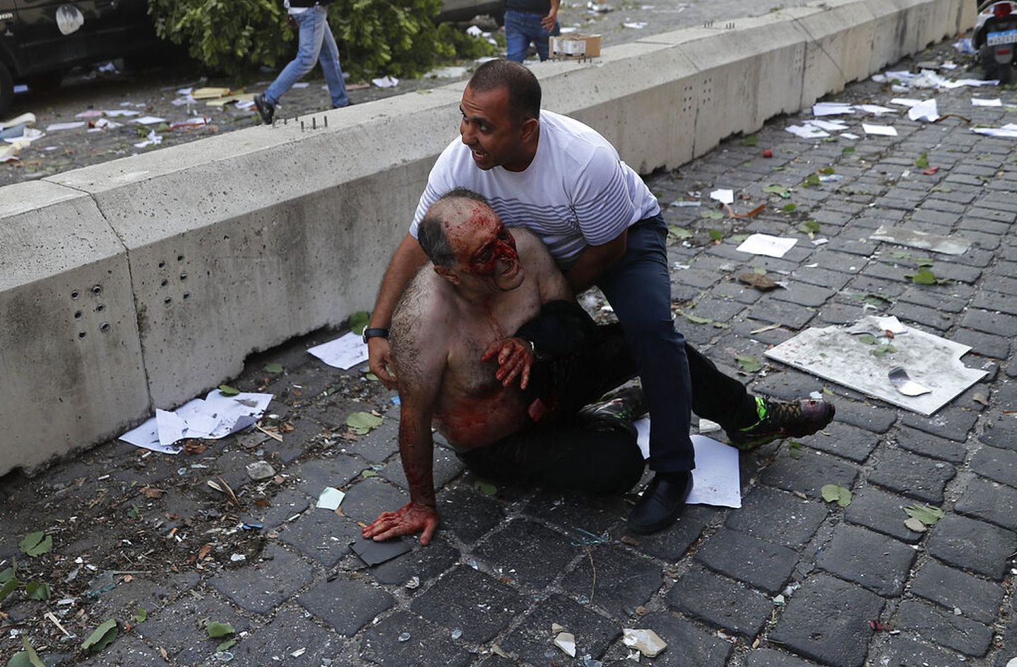 黎巴嫩贝鲁特爆炸：图为8月4日一名男子在爆炸发生后协助另一名伤者。（AP）