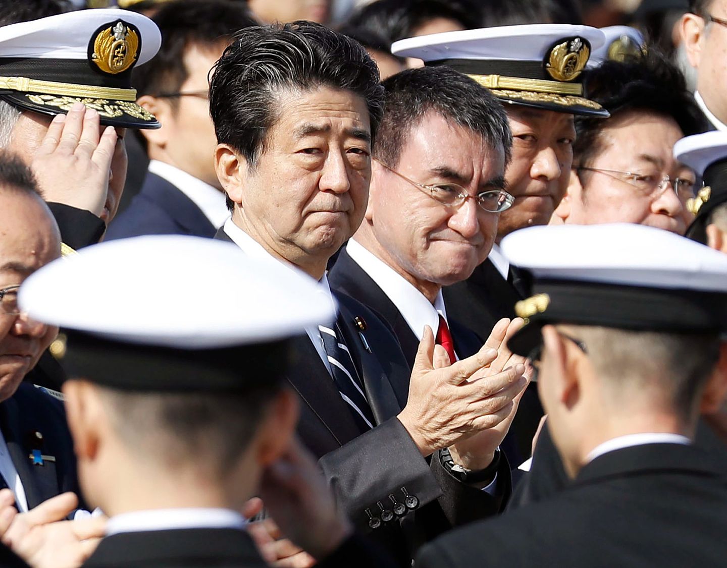 2020年2月2日，日本首相安倍晋三（左中）和防卫大臣河野太郎（中）在东京南部横须贺举行的日本海上自卫队的送别仪式上鼓掌。东京方面在武备上的兴趣也由此突出起来。（美联社）