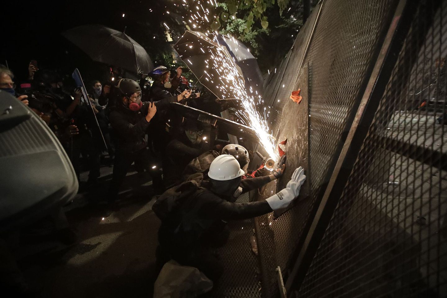 愤怒的示威者试图穿越铁栅栏。（AP）