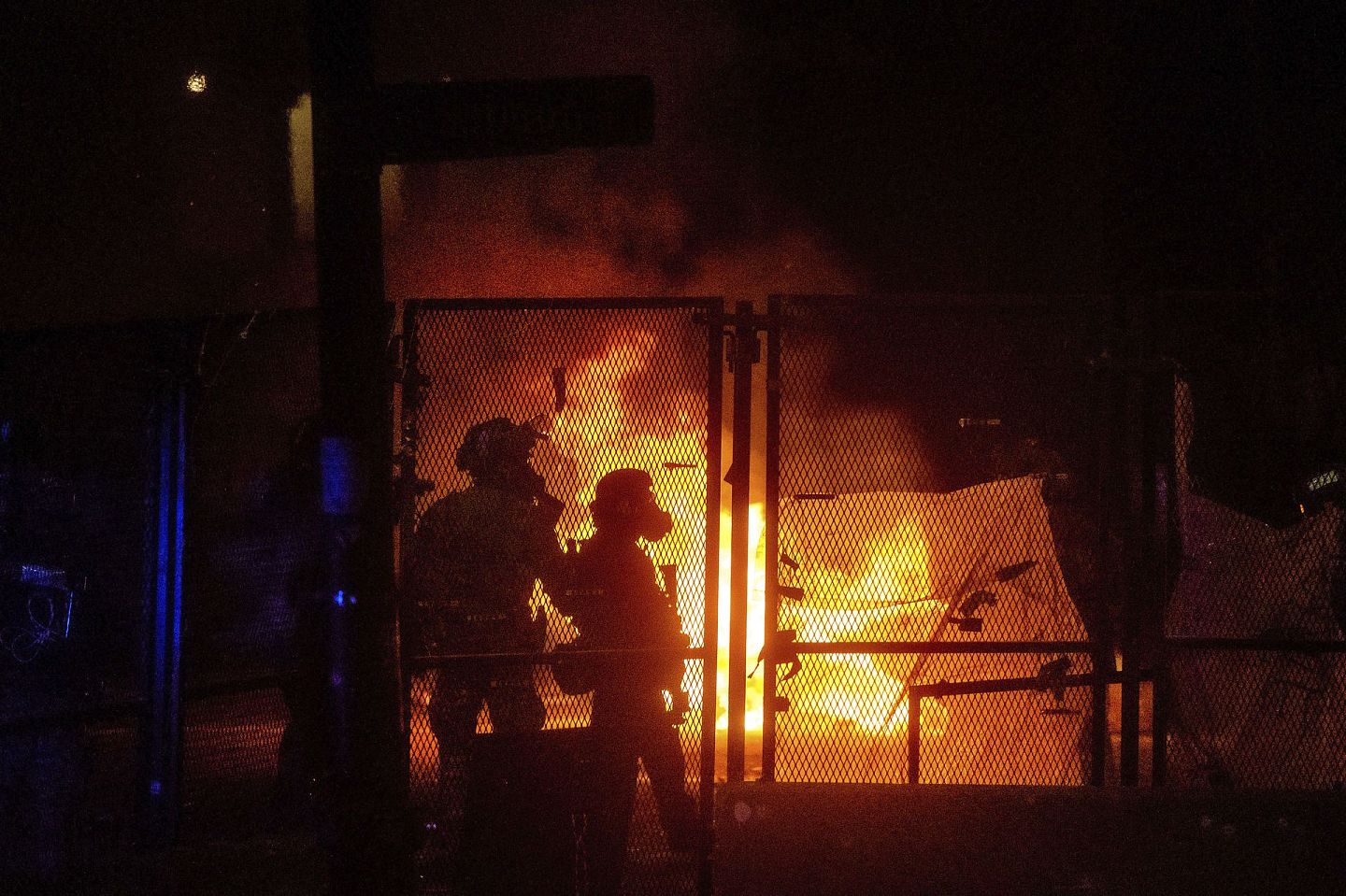 2020年7月25日，抗议者在马克·哈特菲尔德美国法院围墙的另一边放火。（AP）